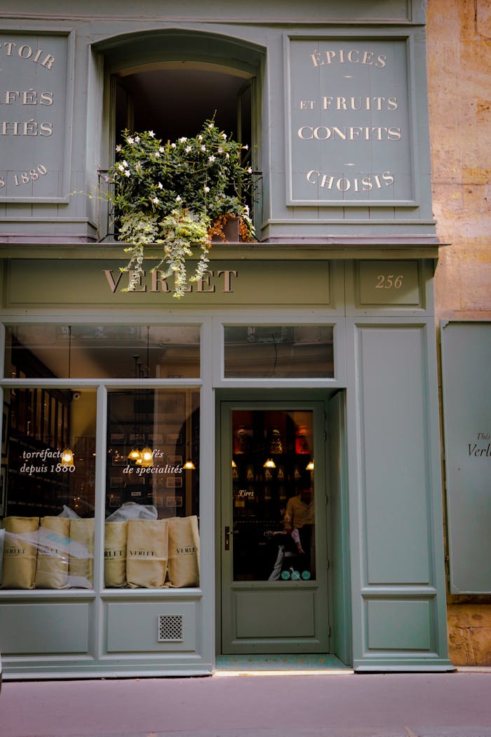 services-04 Charming green storefront in Paris with plants and elegant design elements.